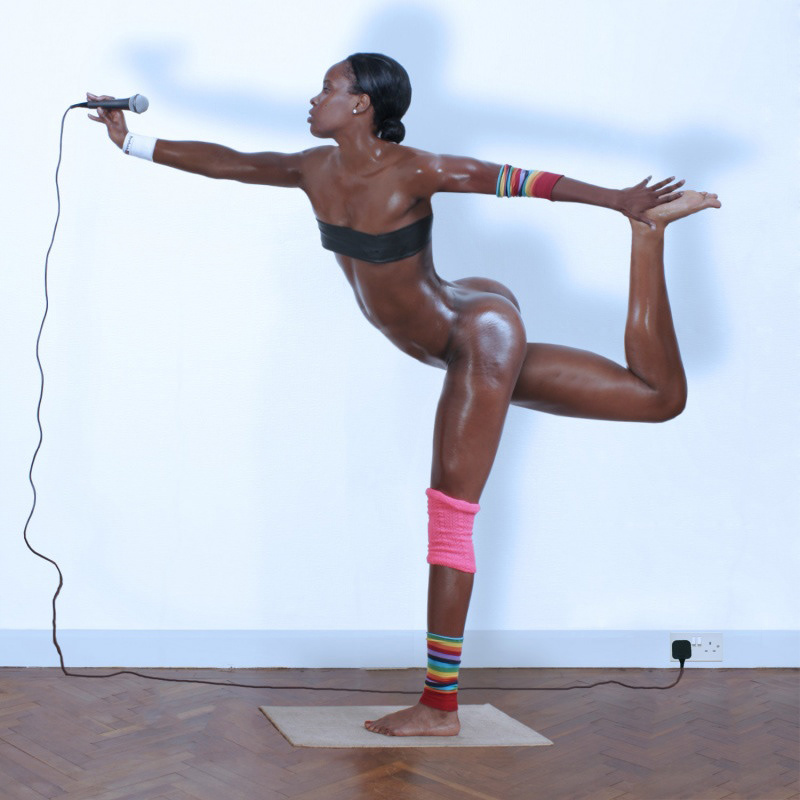 Nude black female model holding a microphone