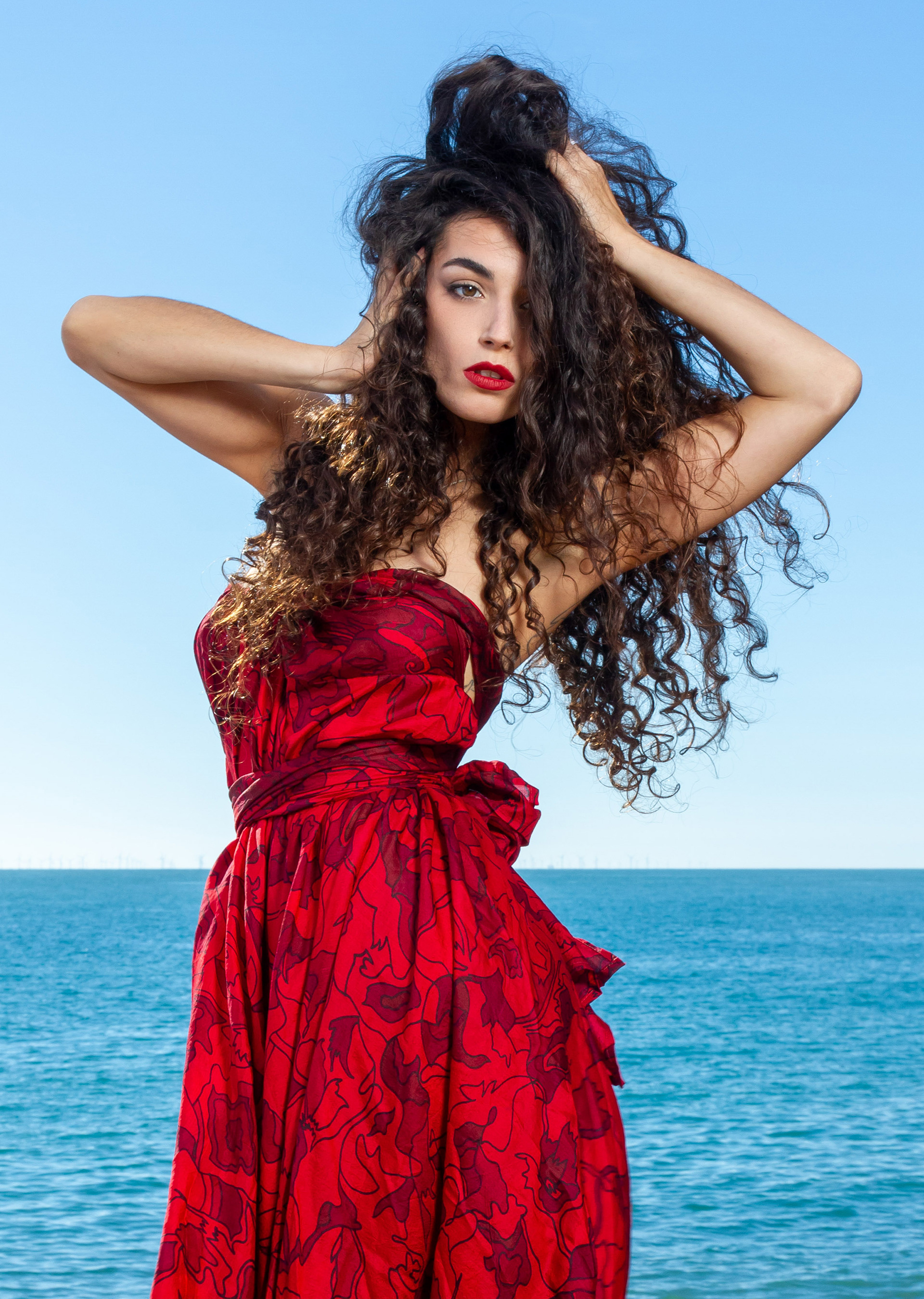 Model wearing a red dress on the beach - photo Taken by Brendan Bishop with his light tent